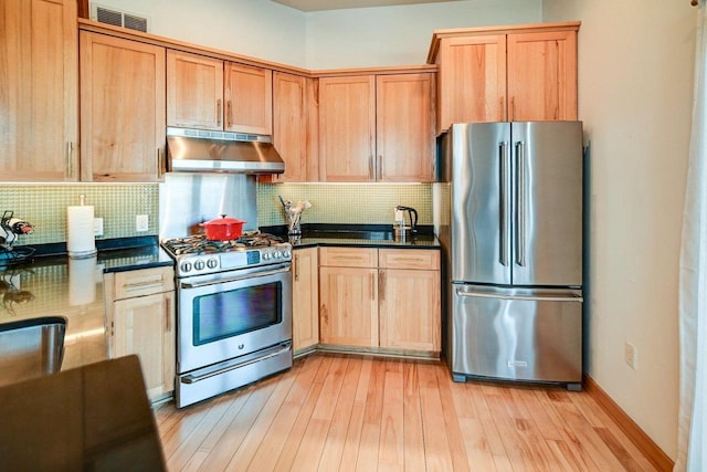 kitchen with visible vents, light wood-style flooring, under cabinet range hood, dark countertops, and appliances with stainless steel finishes