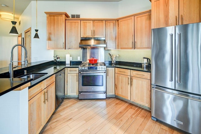 kitchen with visible vents, a sink, light wood-style floors, under cabinet range hood, and appliances with stainless steel finishes