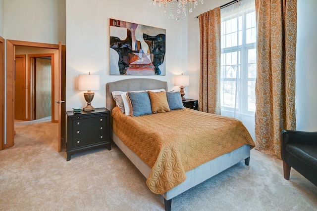 carpeted bedroom with a high ceiling and a notable chandelier