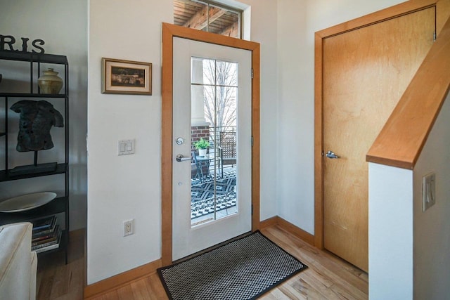 foyer with baseboards and light wood-style floors