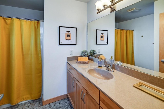 bathroom featuring visible vents, baseboards, and vanity