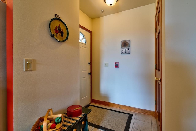 foyer featuring light tile patterned flooring and baseboards