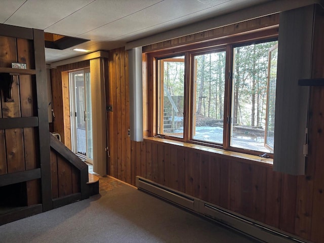 entryway with plenty of natural light, wood walls, and a baseboard radiator