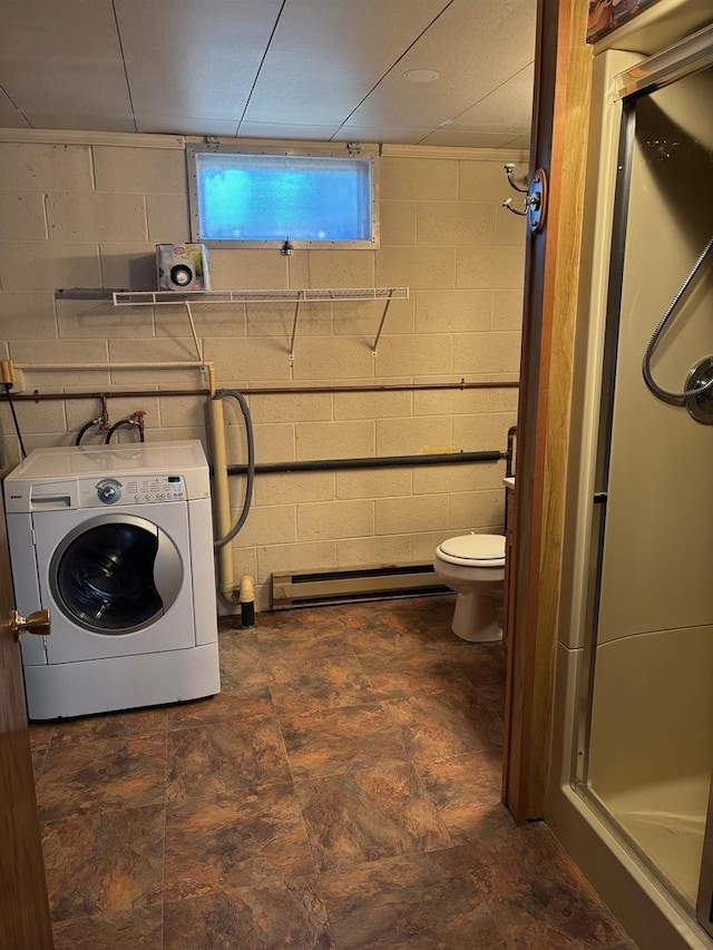 washroom featuring laundry area, washer / dryer, concrete block wall, and a baseboard radiator