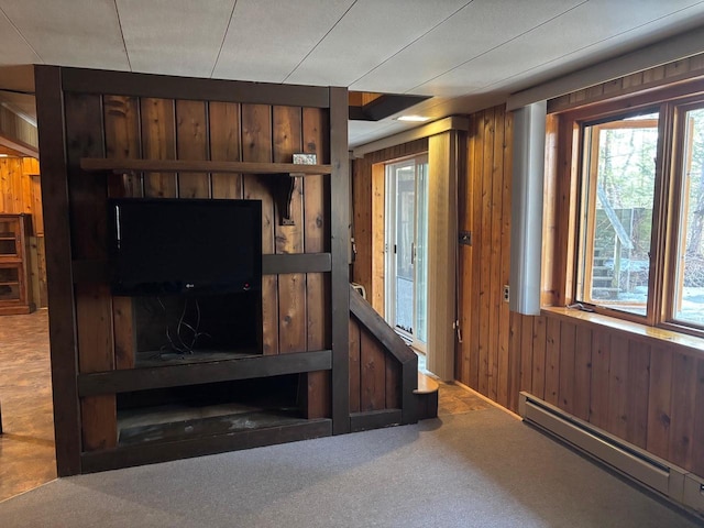 living area featuring wooden walls, carpet flooring, and a baseboard heating unit