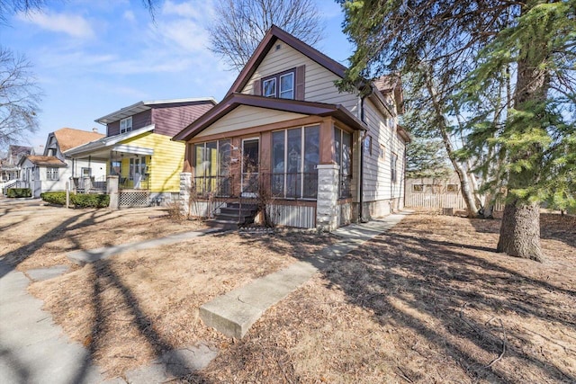 view of front of house with fence and a sunroom