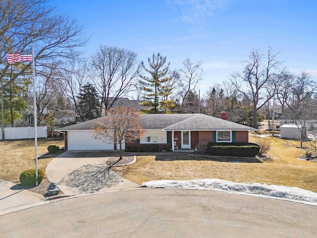 view of front facade with fence, driveway, a front lawn, a garage, and brick siding