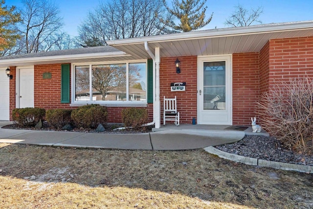 doorway to property featuring brick siding