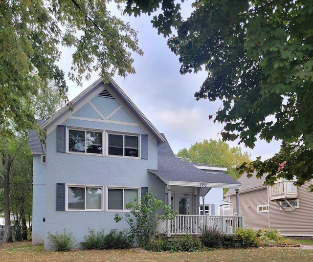 view of front facade featuring roof with shingles and stucco siding