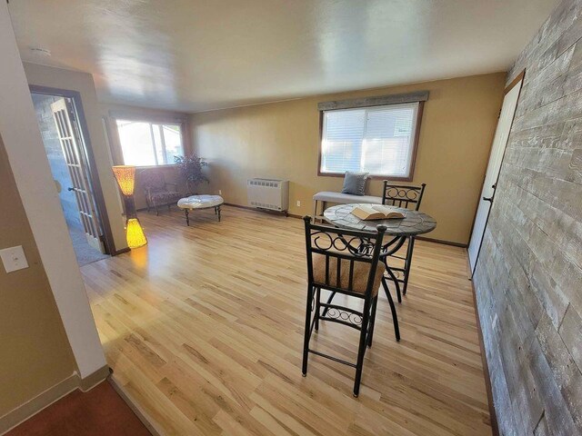 dining space featuring light wood-style flooring, heating unit, and baseboards