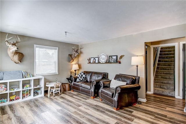 living room with stairway, wood finished floors, and baseboards