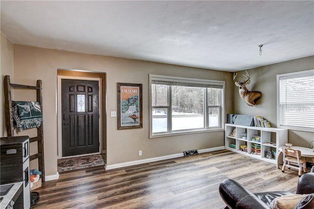 interior space with visible vents, baseboards, and wood finished floors