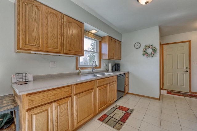 kitchen with baseboards, light countertops, black dishwasher, light tile patterned floors, and a sink