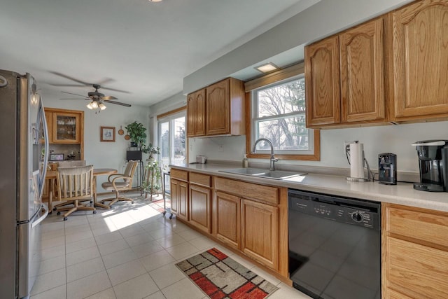 kitchen featuring light tile patterned floors, freestanding refrigerator, a sink, light countertops, and black dishwasher