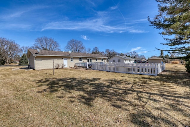 rear view of house featuring a fenced front yard and a yard