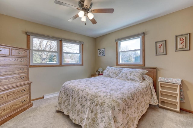 bedroom with light colored carpet, a ceiling fan, a baseboard heating unit, and baseboards