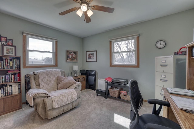 office area with a wealth of natural light, light colored carpet, and a ceiling fan