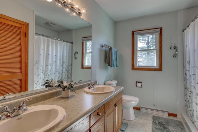 bathroom with a baseboard radiator, a wealth of natural light, and a sink