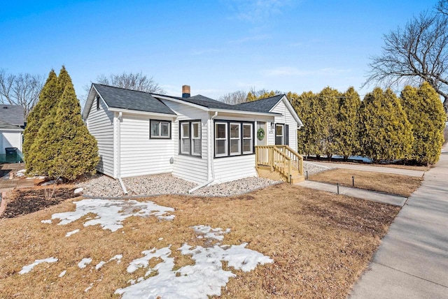 view of front of house with a chimney and a shingled roof