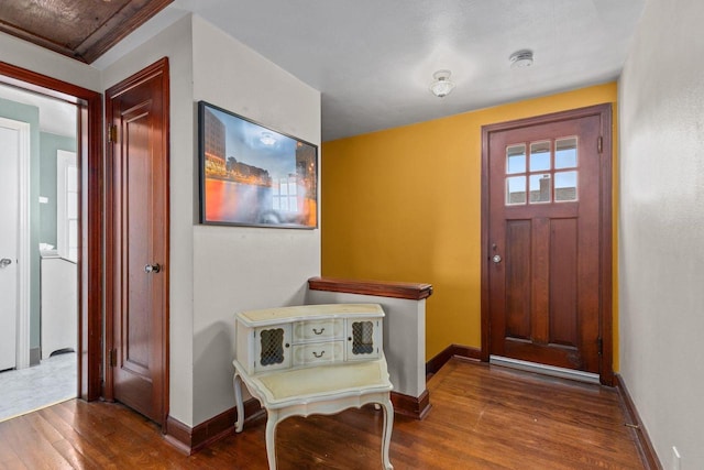 foyer with baseboards and wood finished floors