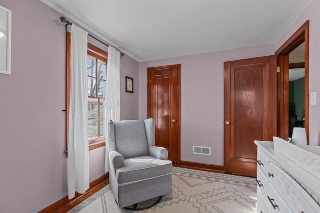 living area with baseboards and visible vents