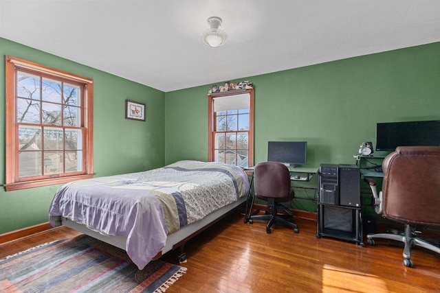 bedroom featuring hardwood / wood-style flooring and baseboards