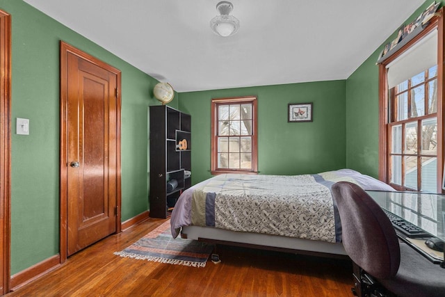 bedroom with baseboards and wood finished floors