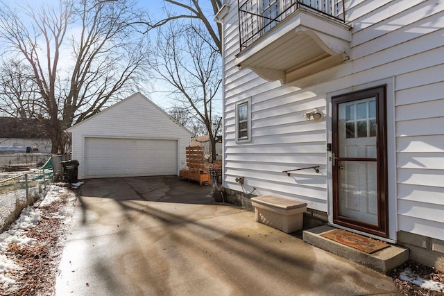 property entrance featuring a garage, a balcony, and fence