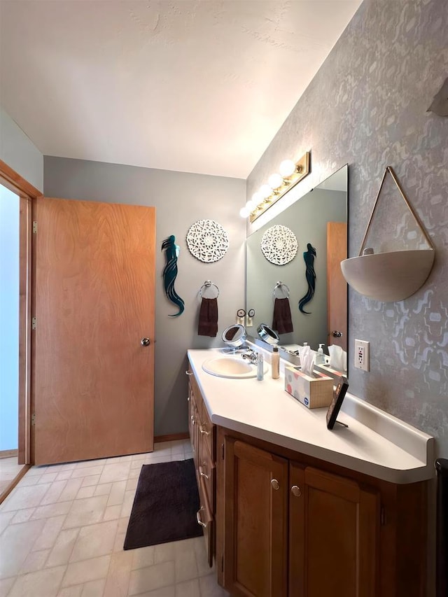 bathroom featuring wallpapered walls and vanity