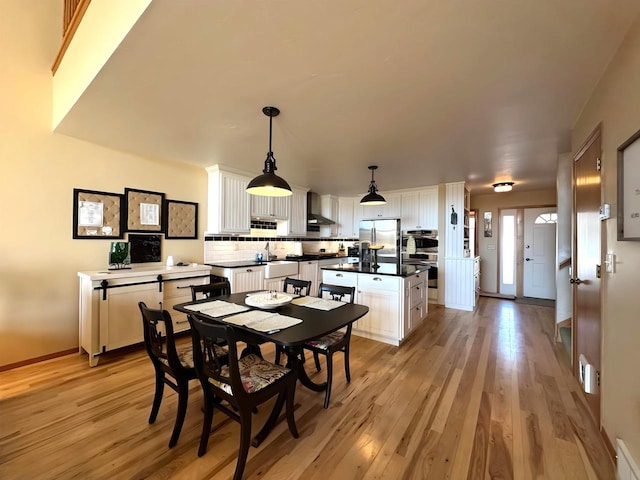 dining area with baseboards and light wood-style floors