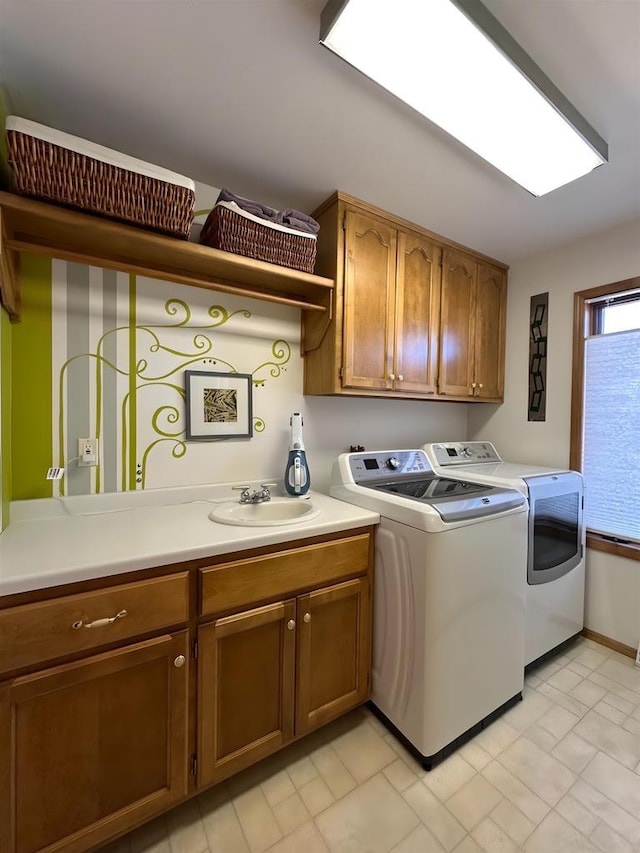 laundry area featuring a sink, cabinet space, and independent washer and dryer