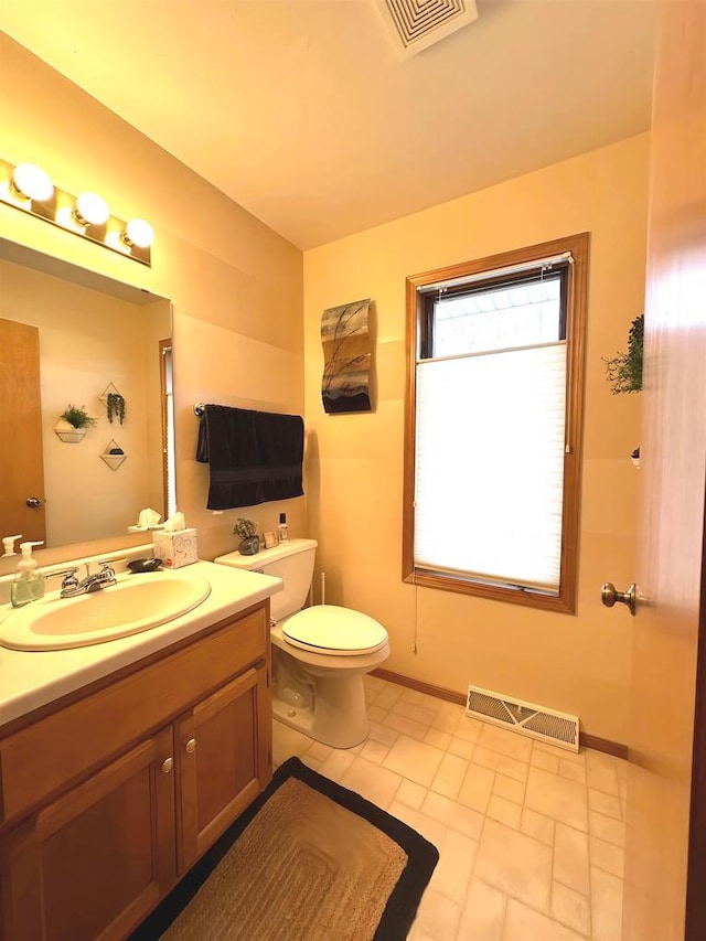 bathroom with visible vents, baseboards, toilet, and vanity