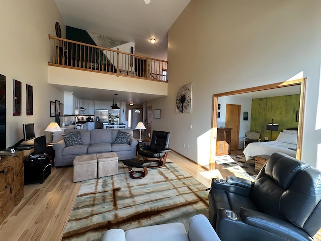 living room featuring light wood finished floors and a towering ceiling