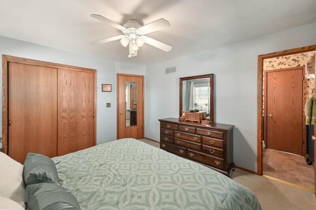 carpeted bedroom with baseboards, visible vents, a closet, and ceiling fan