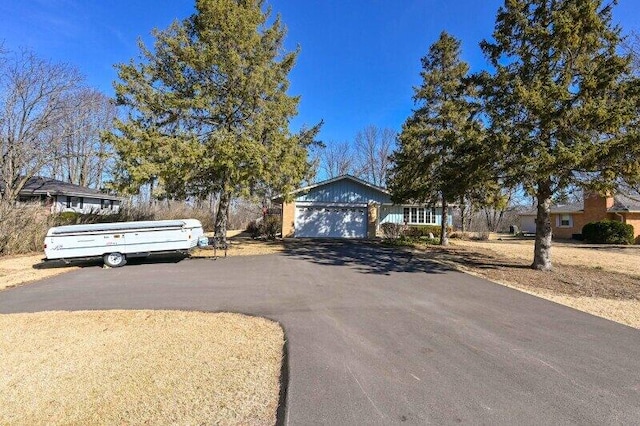 ranch-style home with aphalt driveway and an attached garage