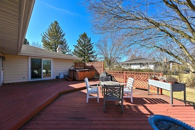 wooden terrace with area for grilling, outdoor dining area, and a hot tub