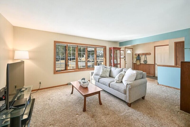 carpeted living area featuring baseboards