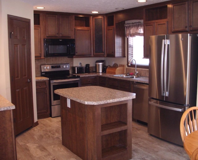 kitchen with open shelves, stainless steel appliances, light countertops, and a sink