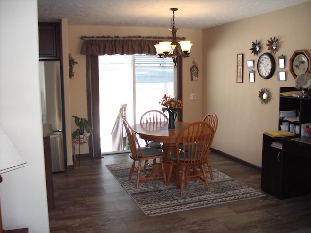 dining room with baseboards, dark wood-type flooring, a chandelier, and a textured ceiling