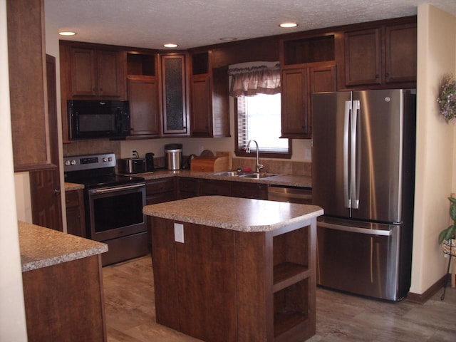 kitchen with a sink, open shelves, light countertops, and stainless steel appliances