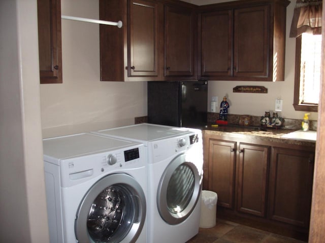 washroom with washing machine and clothes dryer, cabinet space, and a sink