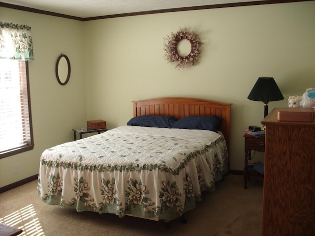 carpeted bedroom featuring baseboards and crown molding