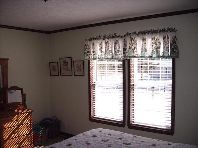 bedroom with a textured ceiling and ornamental molding