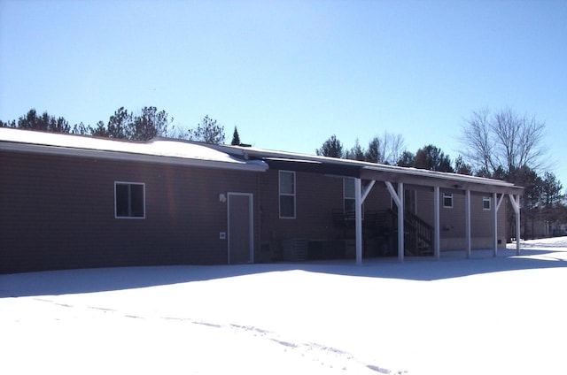 view of snow covered rear of property