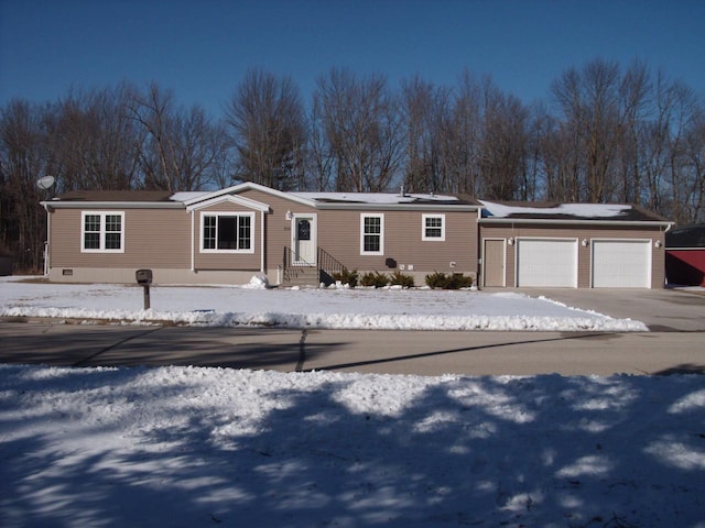 manufactured / mobile home with entry steps, driveway, and a garage