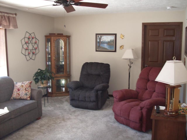 carpeted living area featuring a textured ceiling and ceiling fan