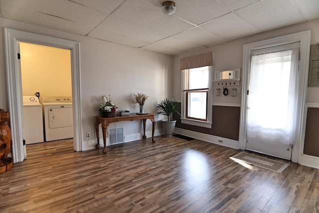 entryway with visible vents, a drop ceiling, wood finished floors, baseboards, and washing machine and clothes dryer