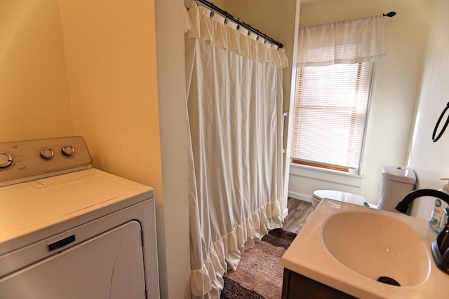 full bath featuring a shower with shower curtain, washer / clothes dryer, toilet, and vanity