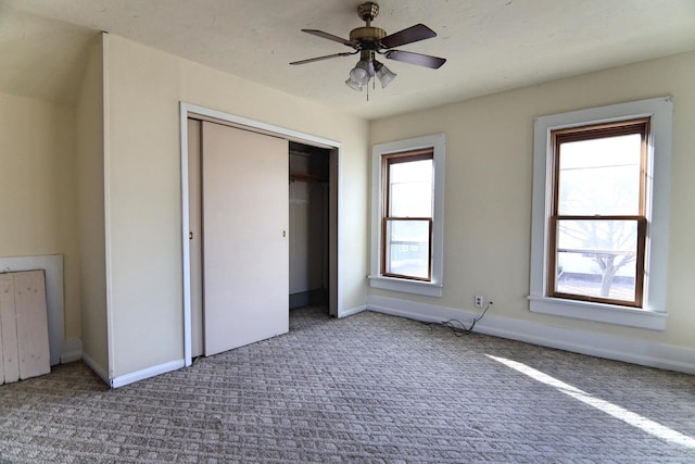 unfurnished bedroom with a closet, baseboards, carpet, and a ceiling fan