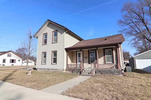 traditional home featuring a porch, cooling unit, a front yard, and an outdoor structure